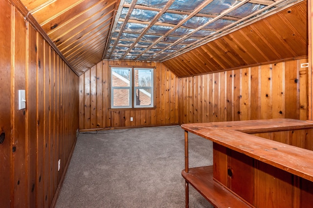 additional living space with lofted ceiling, carpet flooring, and wooden walls