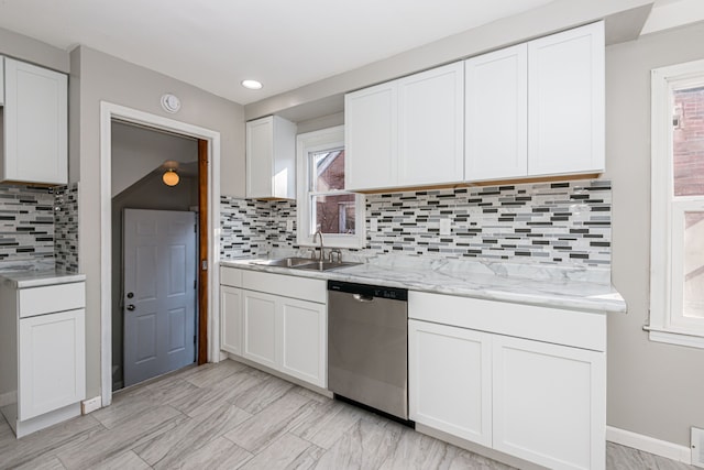 kitchen with sink, light stone counters, dishwasher, white cabinets, and backsplash