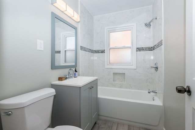 full bathroom featuring tiled shower / bath combo, vanity, wood-type flooring, and toilet