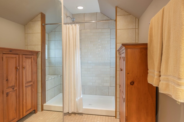 bathroom with vaulted ceiling and a shower with shower curtain