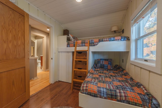 unfurnished bedroom featuring vaulted ceiling and hardwood / wood-style floors