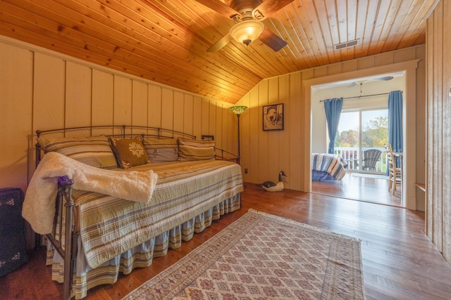 bedroom featuring vaulted ceiling, wooden ceiling, wooden walls, ceiling fan, and hardwood / wood-style floors