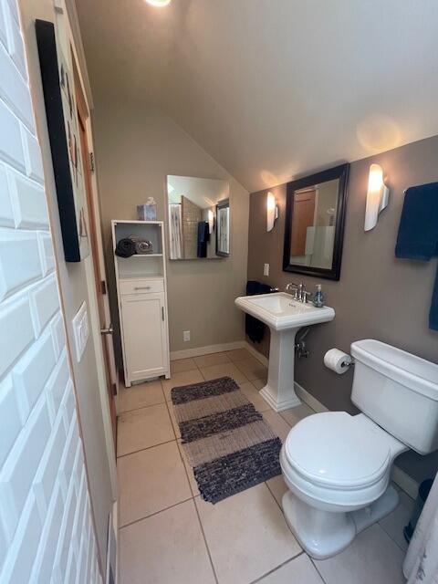 bathroom featuring toilet, tile patterned flooring, and vaulted ceiling