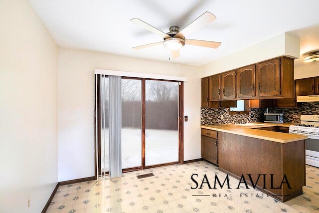 kitchen with dark brown cabinetry, ceiling fan, white range with gas stovetop, ventilation hood, and kitchen peninsula