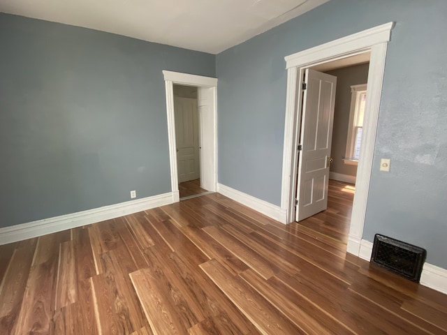 unfurnished bedroom with dark hardwood / wood-style floors