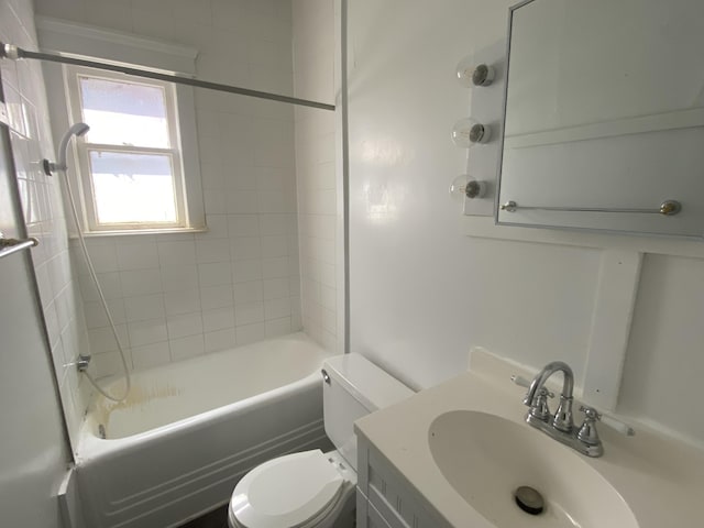 full bathroom with tiled shower / bath combo, toilet, and vanity