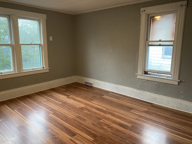 spare room with hardwood / wood-style floors and ornamental molding