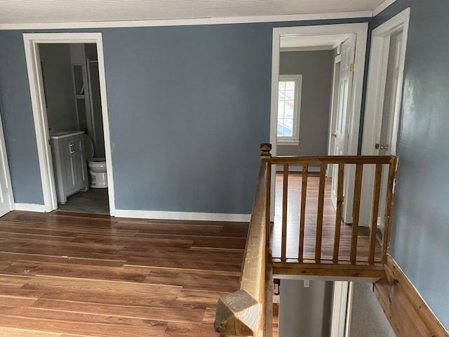 staircase featuring wood-type flooring and crown molding