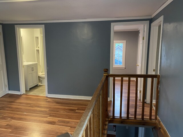 stairs with hardwood / wood-style floors and ornamental molding