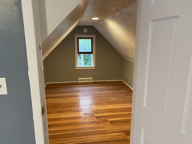 additional living space featuring hardwood / wood-style flooring and lofted ceiling