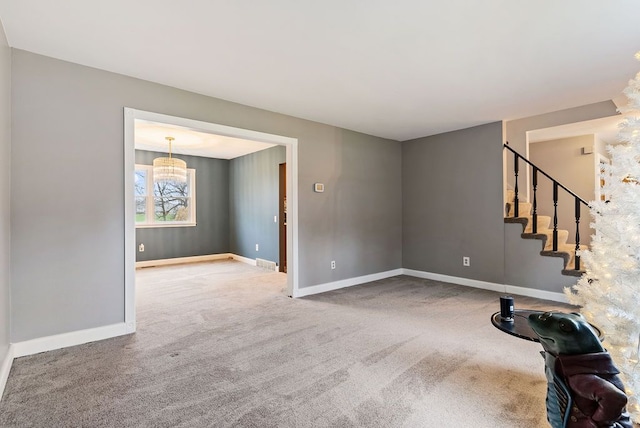 unfurnished living room with carpet floors and an inviting chandelier