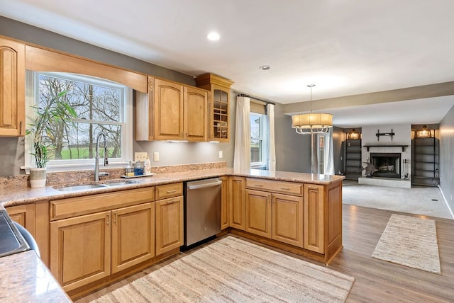 kitchen with kitchen peninsula, sink, pendant lighting, light hardwood / wood-style flooring, and dishwasher