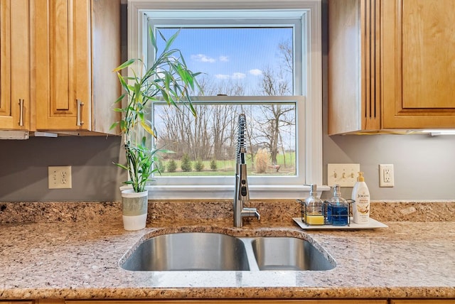 kitchen featuring light stone countertops and sink