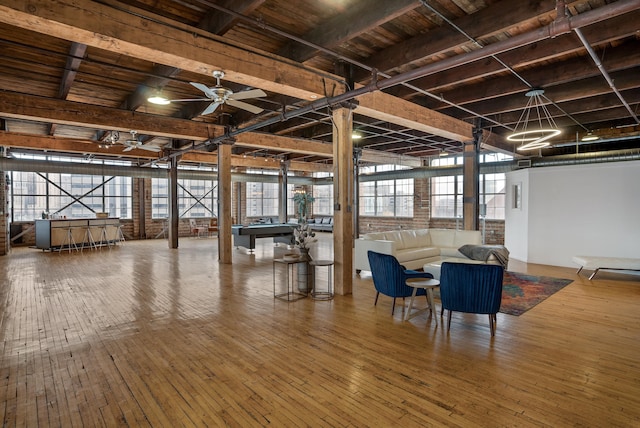 unfurnished dining area featuring ceiling fan, beamed ceiling, billiards, and hardwood / wood-style flooring