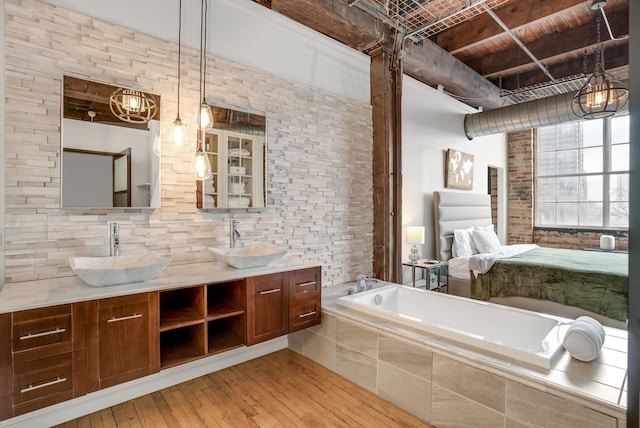 bathroom featuring a relaxing tiled tub, wood-type flooring, vanity, and wooden ceiling