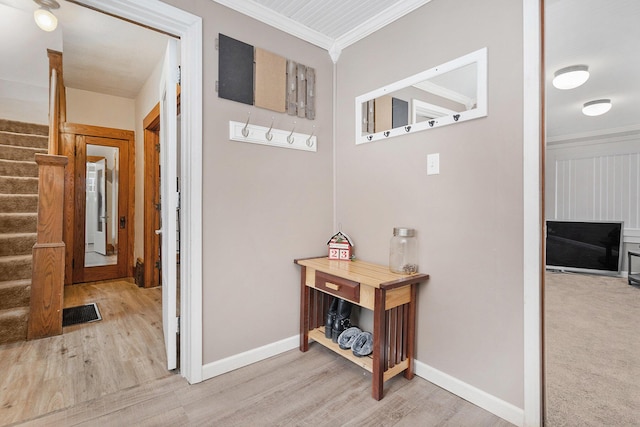 hall with crown molding and light hardwood / wood-style flooring