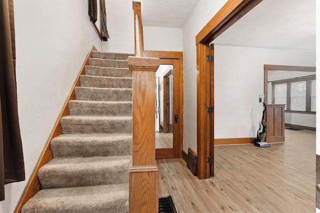 stairs featuring hardwood / wood-style floors