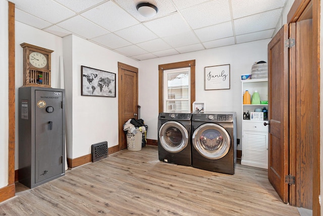 clothes washing area featuring light wood-type flooring and washing machine and clothes dryer