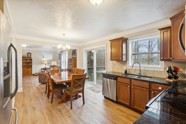 kitchen featuring tasteful backsplash, stainless steel appliances, sink, light hardwood / wood-style flooring, and a chandelier