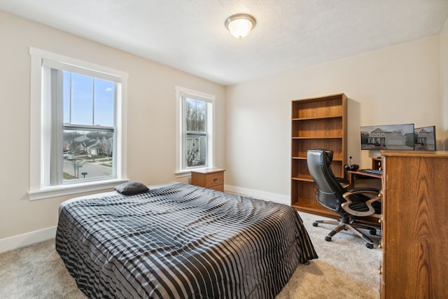 bedroom with a textured ceiling and light carpet