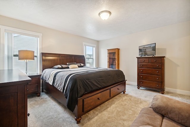 bedroom with light colored carpet and a textured ceiling