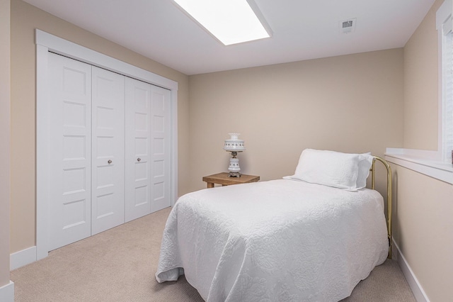 bedroom with light carpet and a closet