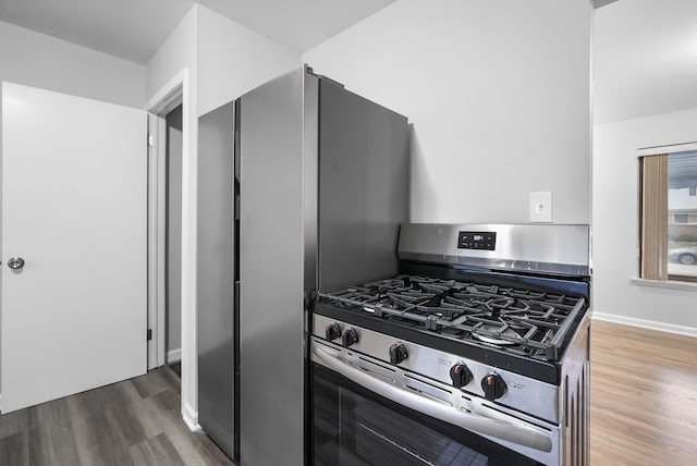 kitchen featuring stainless steel gas range oven and dark hardwood / wood-style flooring