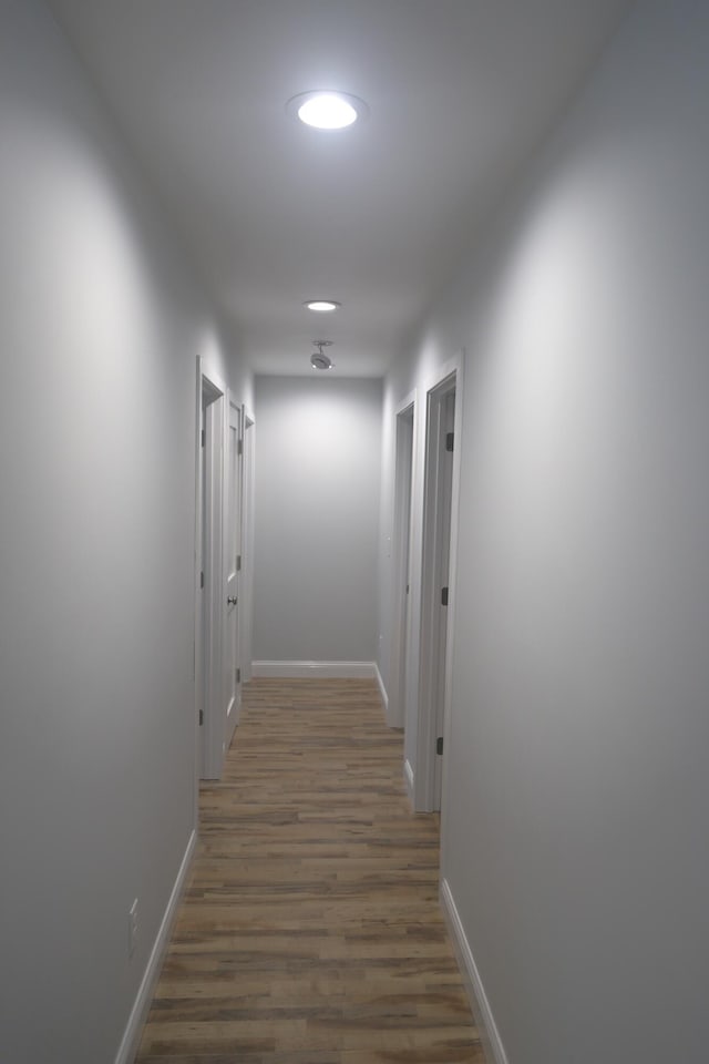 corridor featuring recessed lighting, baseboards, and wood finished floors