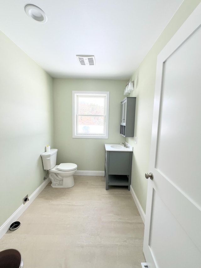 bathroom featuring vanity, wood finished floors, baseboards, visible vents, and toilet