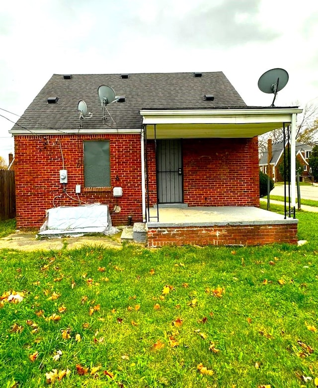 rear view of house featuring a lawn