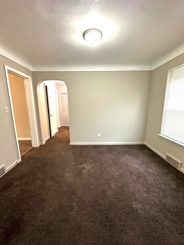 carpeted empty room featuring a textured ceiling