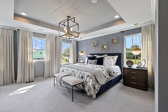 bedroom featuring light colored carpet, a raised ceiling, and a notable chandelier