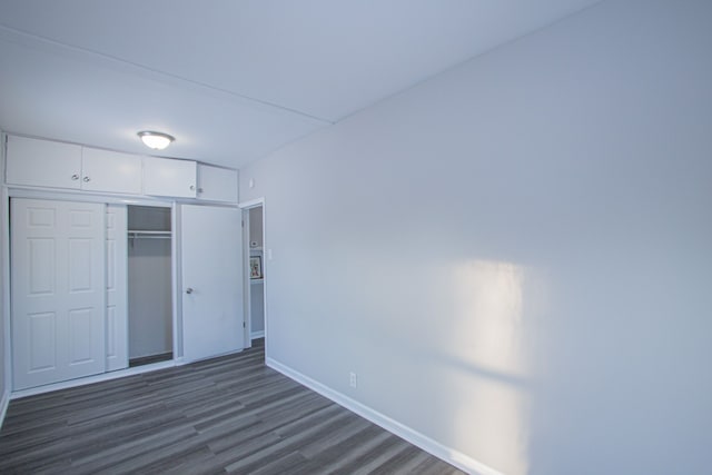 unfurnished bedroom featuring dark hardwood / wood-style flooring and a closet