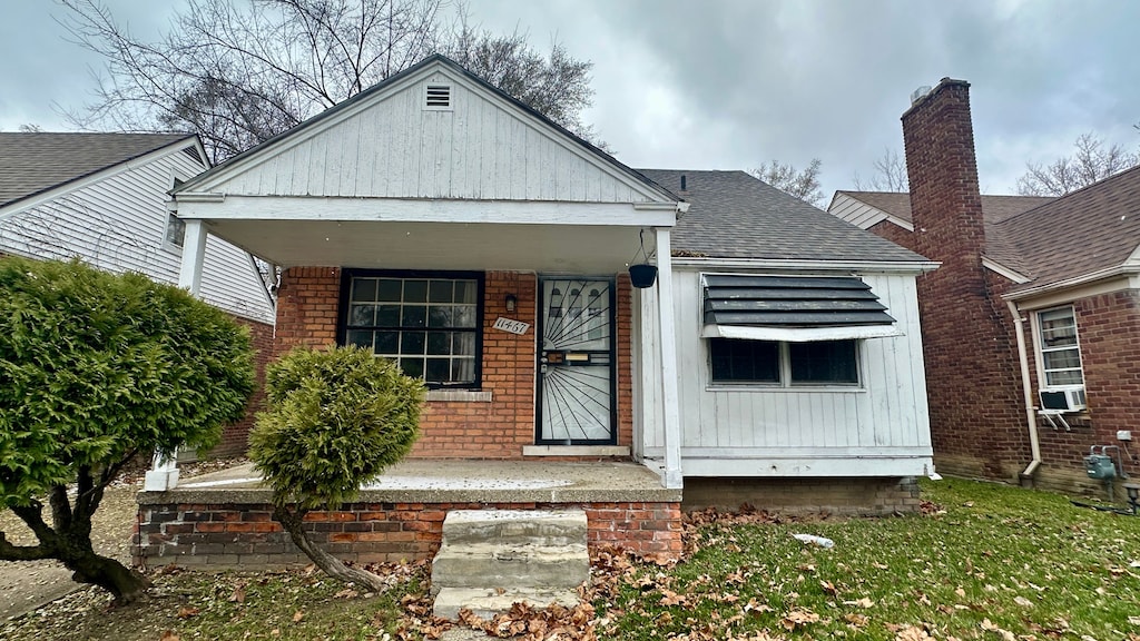 bungalow-style home with cooling unit and a porch