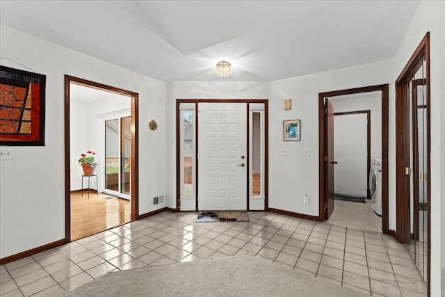 tiled entryway with washer / dryer