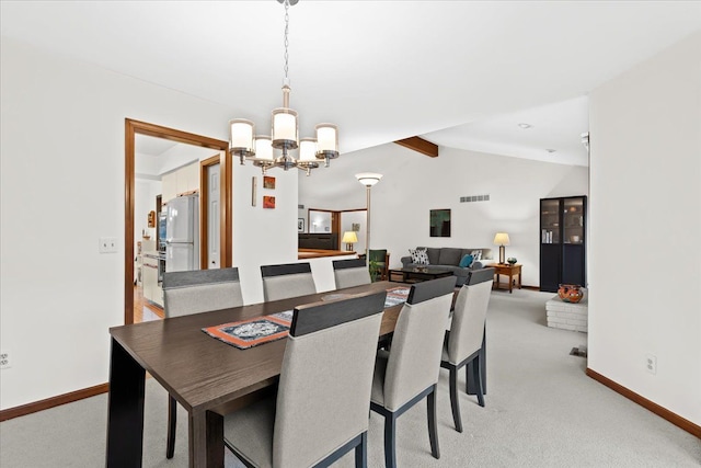 dining room with lofted ceiling with beams, light colored carpet, and a chandelier