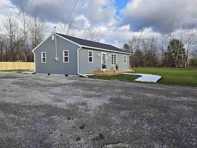 view of front of home featuring a front lawn and a wooden deck