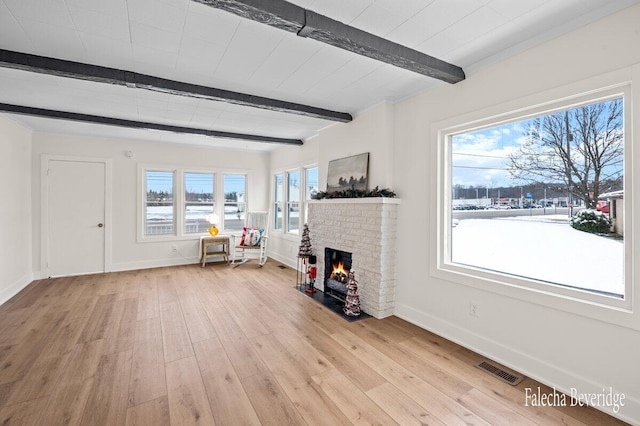 unfurnished living room with a fireplace, plenty of natural light, and light wood-type flooring