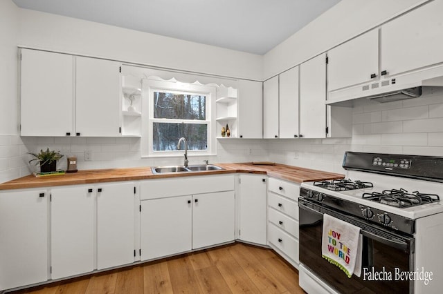 kitchen featuring white range with gas stovetop, sink, light hardwood / wood-style flooring, tasteful backsplash, and white cabinetry