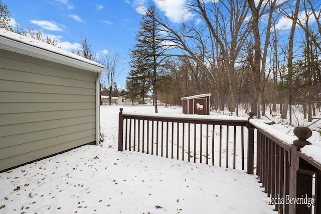 snow covered deck featuring a storage unit