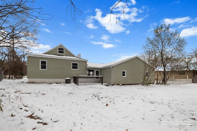 snow covered back of property featuring a deck