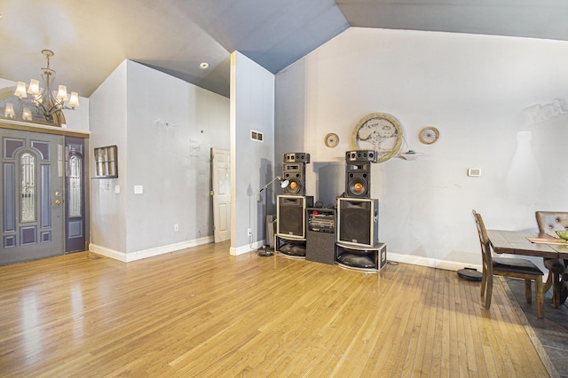 entrance foyer with hardwood / wood-style floors, high vaulted ceiling, and an inviting chandelier