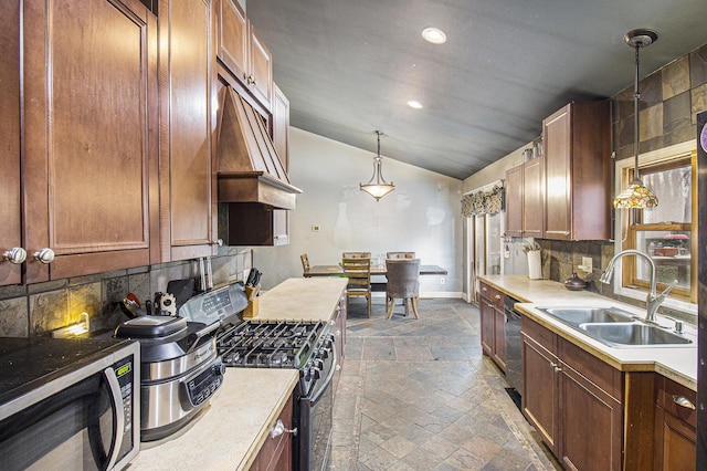 kitchen featuring sink, hanging light fixtures, stainless steel appliances, lofted ceiling, and decorative backsplash