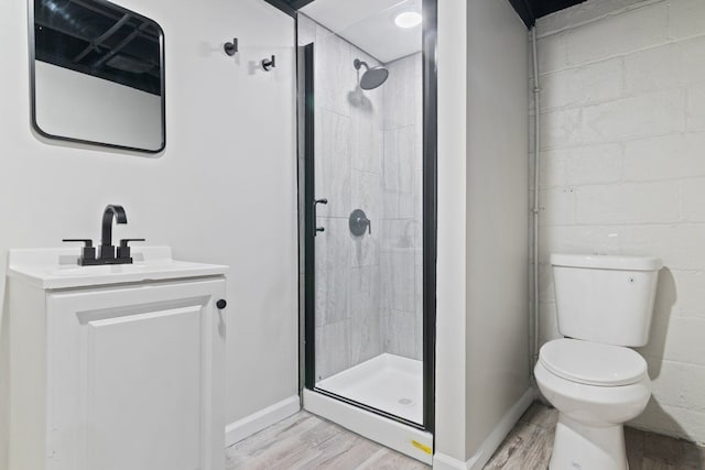 bathroom with toilet, vanity, wood-type flooring, and walk in shower