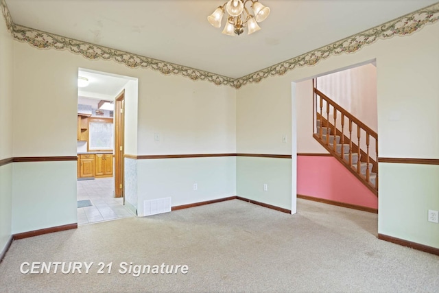 carpeted empty room with a chandelier