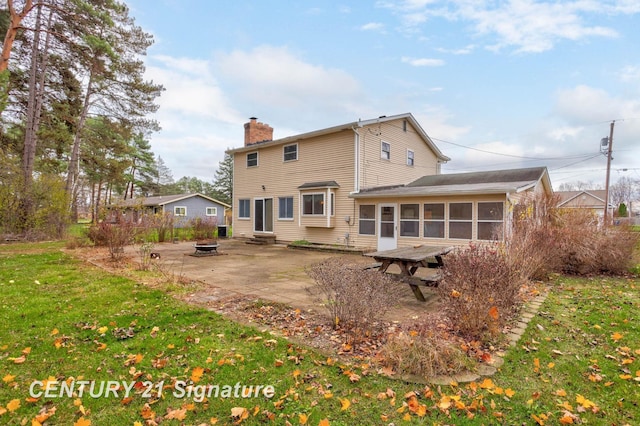 rear view of property with a lawn, a sunroom, and a patio