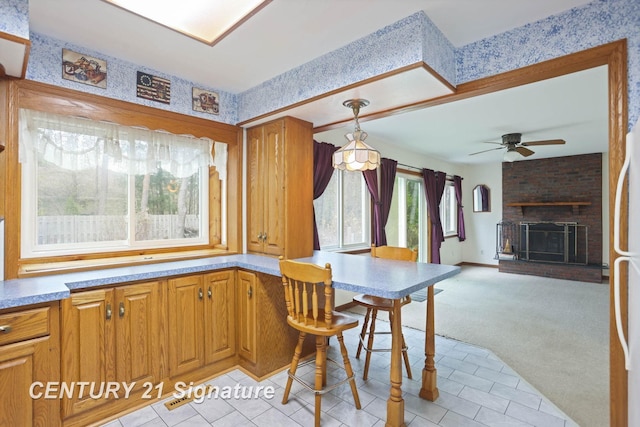 dining space with a fireplace, ceiling fan, and light carpet