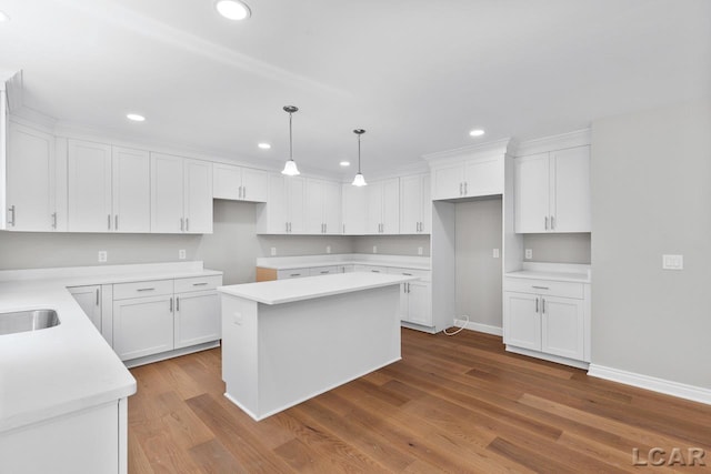 kitchen with pendant lighting, white cabinetry, hardwood / wood-style flooring, and a kitchen island