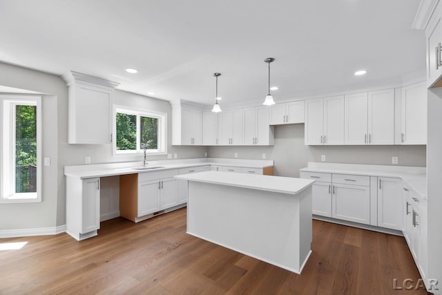 kitchen featuring a center island, white cabinets, hanging light fixtures, and sink