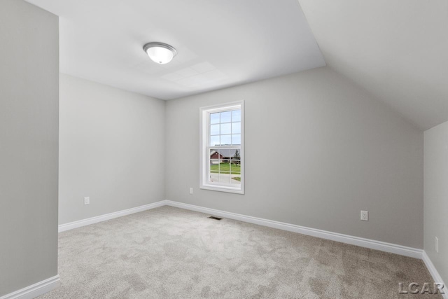 additional living space with vaulted ceiling and light colored carpet